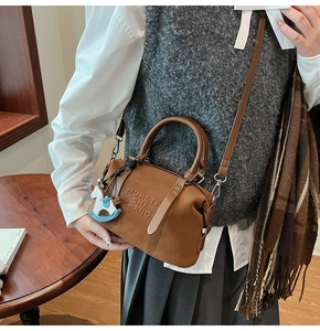 Brown leather Boston bag with MUHETI engraving and a cute little horse pendant