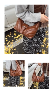 Gros plan sur un sac vintage en cuir marron avec clous argentés et boucle décorative