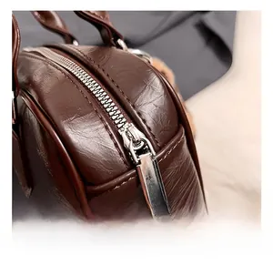 Macro shot of silver metal zipper and dark brown litchi grain leather on fashion bowling bag