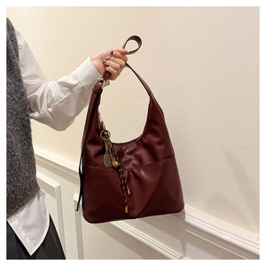 Détail du sac Hobo bordeaux en similicuir texturé avec pendentif raquette de tennis