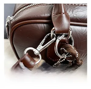 Close-up of silver zipper and brown pebble leather texture with leopard fur ball charm