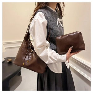 Détail du sac cabas en cuir marron foncé et pochette assortie avec tirette de zip tressée