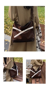 Deep brown tote bag with white shearling trim and slim straps in an autumn park setting