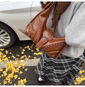 Sac bandoulière demi-lune marron avec rivets argentés et design biker vintage sur modèle