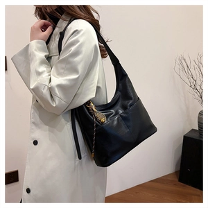 Détail du sac demi-lune noir avec pendentif raquette de tennis et cordon tressé déco