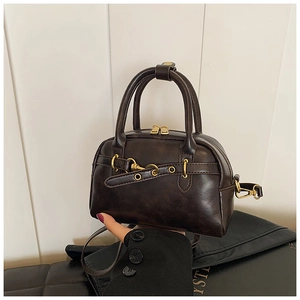 Vue détaillée d'un sac à main vintage marron en cuir avec boucle dorée et bandoulière