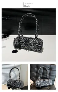 Detail of leopard print shoulder bag featuring black bow and heart leather tag