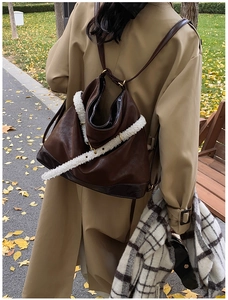 Close-up of brown vintage backpack with warm white faux fur shoulder strap detail