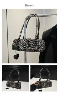Close-up of leopard print shoulder bag with black bow and heart-shaped charm accessory