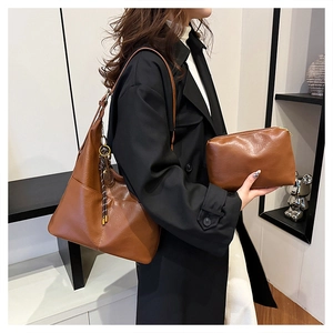 Détail du grand sac cabas en cuir marron avec pompon et petite pochette assortie