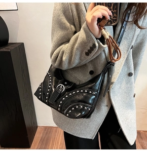Détail d'un sac punk noir avec des rivets argentés et des fermetures éclair style motard