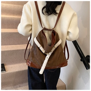 Detail showing brown leather tote bag with white fleece decorative strap in lifestyle setting