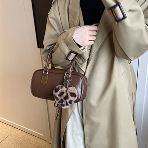 Deep brown faux leather retro bowling bag with leopard print heart charm on casual model