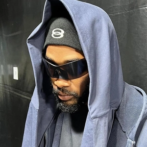 Futuristic rimless Y2K sports sunglasses for men styled with a black beanie and hoodie