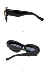 Detail view of black cat eye sunglasses with gold hinge accents on side and back