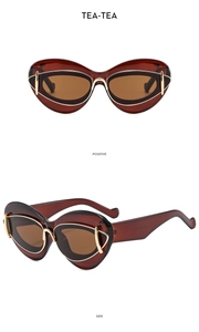 Detail view of tea-colored cat eye sunglasses with gold metal hinges and dark lenses