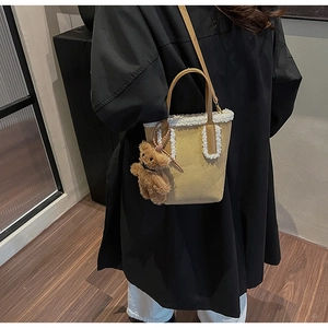 Dettaglio borsa tote in pelle scamosciata color cammello con bordo in pelliccia bianca