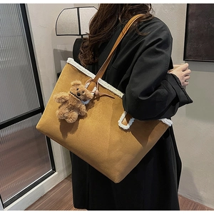 Dettaglio della borsa tote color cammello con bordo in peluche bianco e ciondolo a orso