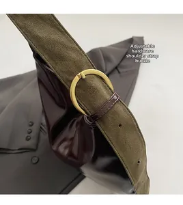 Detail of adjustable gold buckle connecting dark patent leather bag and green suede strap