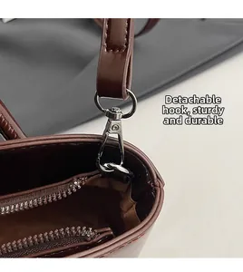 Close-up of durable detachable silver metal hook and zipper on brown leather bucket bag