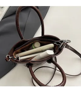 Detail of burgundy leather handbag interior with zipper pocket and large capacity space