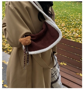 Detailansicht der braunen Wildleder-Hobo-Tasche mit weißem Kunstfellbesatz und Bärenanhänger