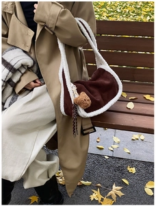 Detail von Lammfellbesatz an dunkelbrauner Wildledertasche mit süßem Bärenanhänger