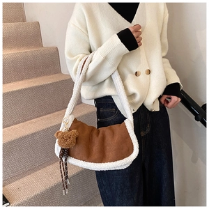 Detail der sichelförmigen Plüschtasche mit braunem Wildleder und weißem Lammfellbesatz