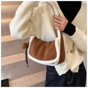 Detail der Schultertasche aus Wildlederimitat mit Lammfellbesatz und dekorativem Pompon