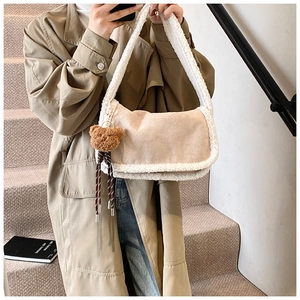Details der beigen Wildleder-Schultertasche mit Fleecebesatz und Bärenanhänger
