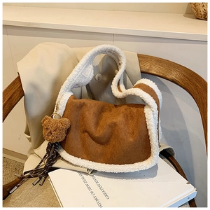 Nahaufnahme der braunen Wildledertasche mit weißem Kunstpelzbesatz und Plüschbär-Anhänger