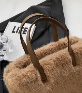 Vue macro d'un sac en peluche marron montrant la fausse fourrure et l'anse en cuir cousu