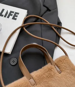 Détail du sac en peluche marron montrant la texture douce et les lanières en cuir lisse