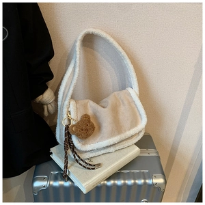 Detail der flauschigen beigen Schultertasche mit Pelzbesatz und Teddybär-Anhänger