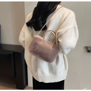 Sac à main en fausse fourrure rose poudré montrant le dos de la sacoche sur un mannequin