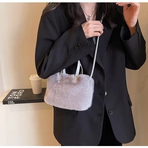 Détail du sac à main en fausse fourrure violet clair porté par un mannequin en blazer