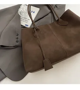 Detailed texture of dark brown suede tote bag with soft fabric and vertical stitching