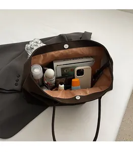 Spacious interior of a dark brown matte tote bag with magnetic closure and smooth lining