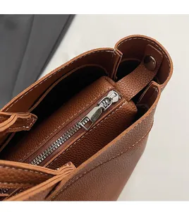Detail of brown lychee leather tote bag with contrast stitching and metal zipper