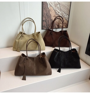 Matte suede tote bags in four neutral colors displayed on wooden stairs with art