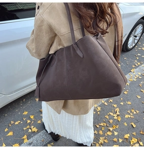 Detail of a large dark brown matte suede tote bag with long handles for autumn style