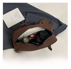 Dettaglio dell'interno capiente di una grande borsa marrone opaca con oggetti quotidiani