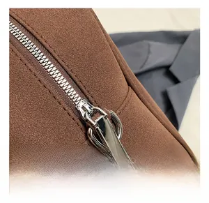 Vista macro di una borsa Boston in pelle scamosciata marrone con zip in metallo argento