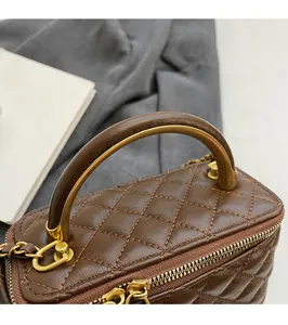 Details der vintage braunen Steppledertasche mit Griff aus Goldmetall und Leder
