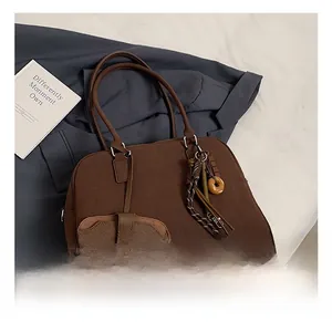 Dettaglio della borsa Boston opaca marrone con ciondolo a nappa e mini portamonete rimovibile