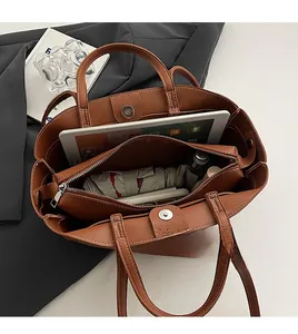 Detailed top view of brown leather tote bag interior with large capacity and zipped compartment