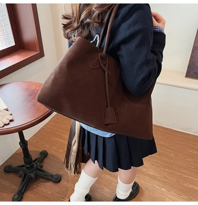 Grande borsa tote in pelle scamosciata caffè scuro indossata in uno stile vintage