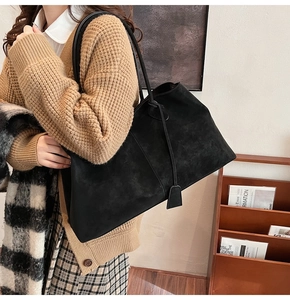 Detail of black suede tote bag with vertical stitching and textured finish