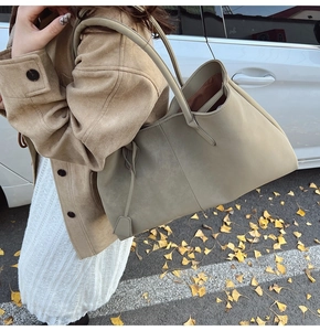 Outdoor shot of a sage green tote bag in suede texture with long shoulder straps