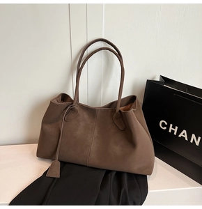 Detail view of large brown tote bag in soft matte suede with elegant long shoulder straps